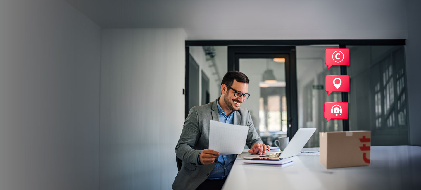 Homem a trabalhar na secretária com um computador portátil e uma caixa de envio Expresso
