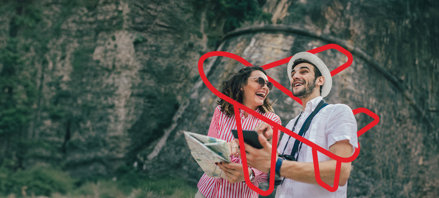 Casal com um mapa na mão durante a sua viagem que está segurada pelo Seguro Viagem.