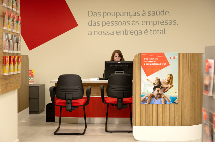Balcão novo da loja CTT renovada, com colaboradora sentada.